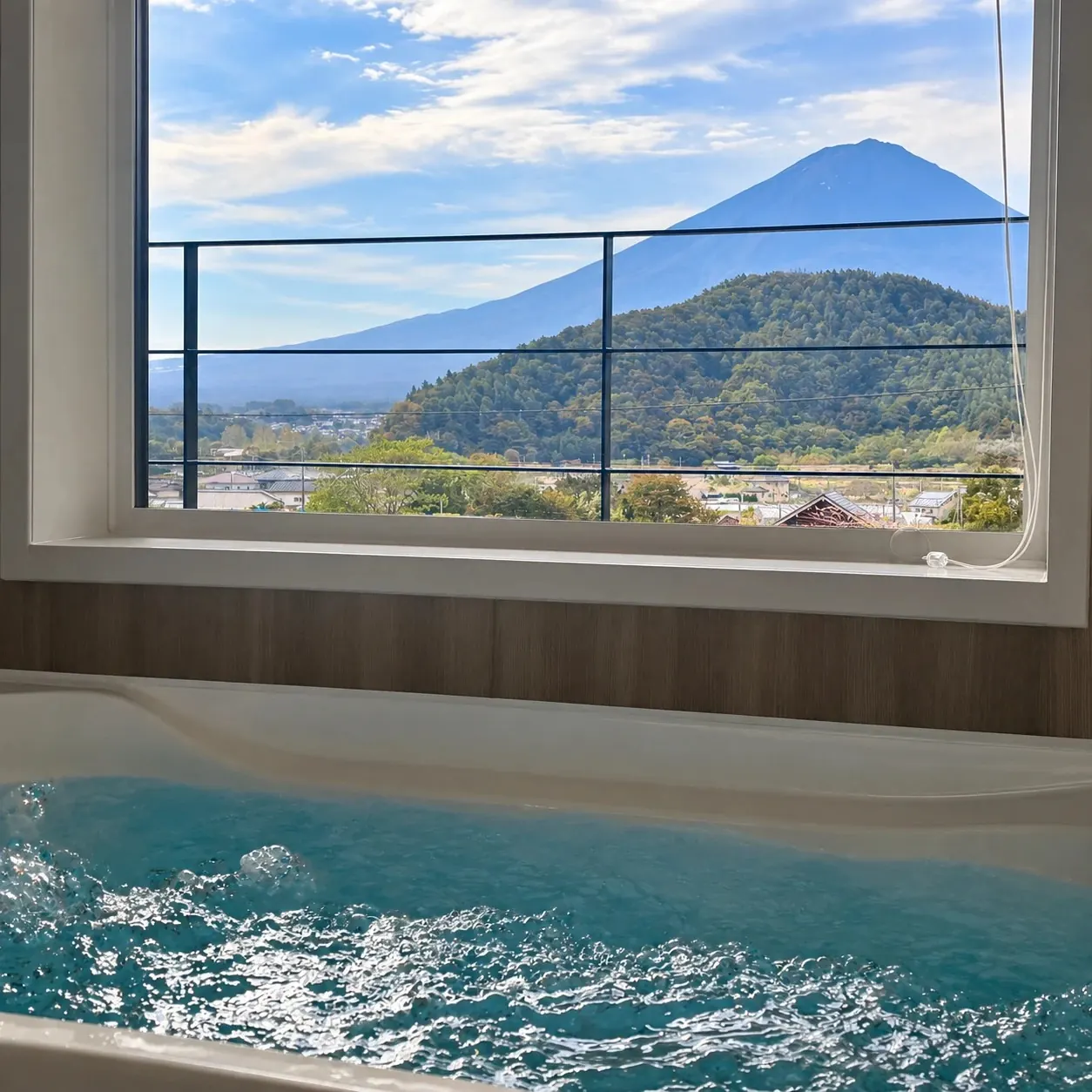 泡立つ浴槽の正面、窓いっぱいに広がる富士山